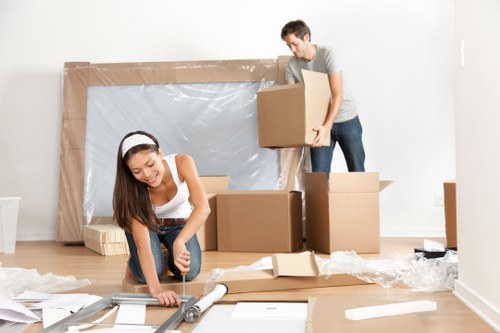 Professional movers unloading boxes and furniture at a new home in Leaves Green